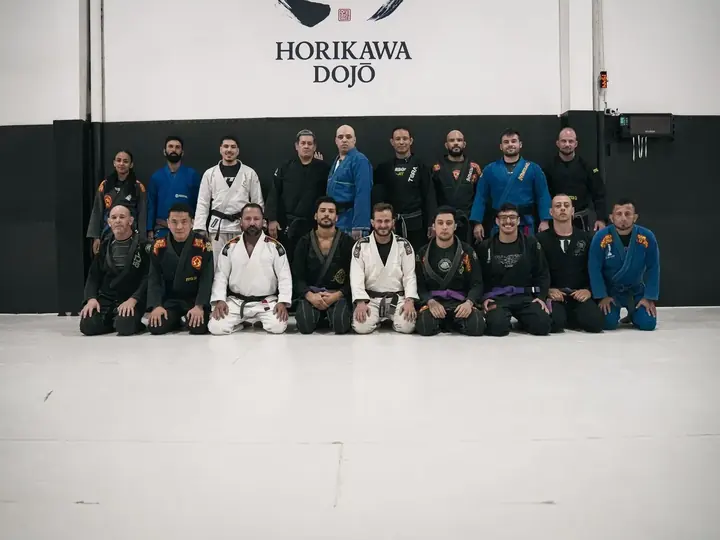Turma de jiu-jitsu adulto reunida no tatame