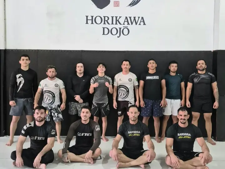 Turma de jiu-jitsu no-gi reunida no tatame