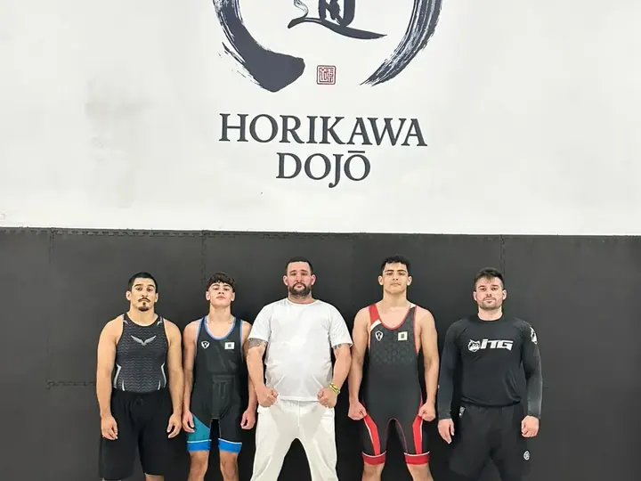 Turma de wrestling reunida no tatame